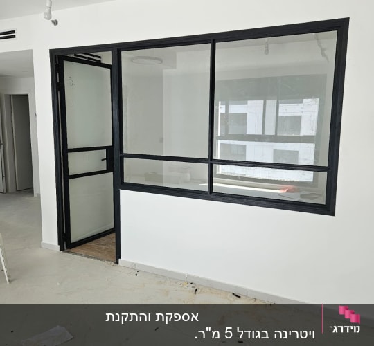 חלון אלומיניום עם מסגרת שחורה על קיר לבן